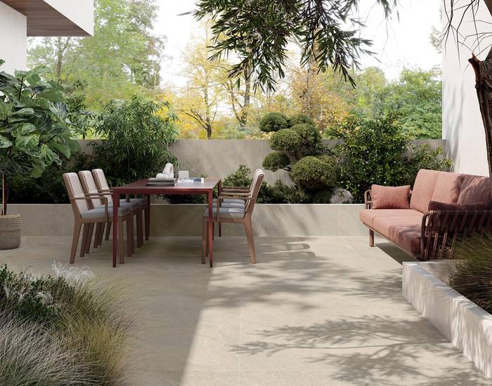 Outdoor terrace with stone‑effect porcelain flooring and dining table.