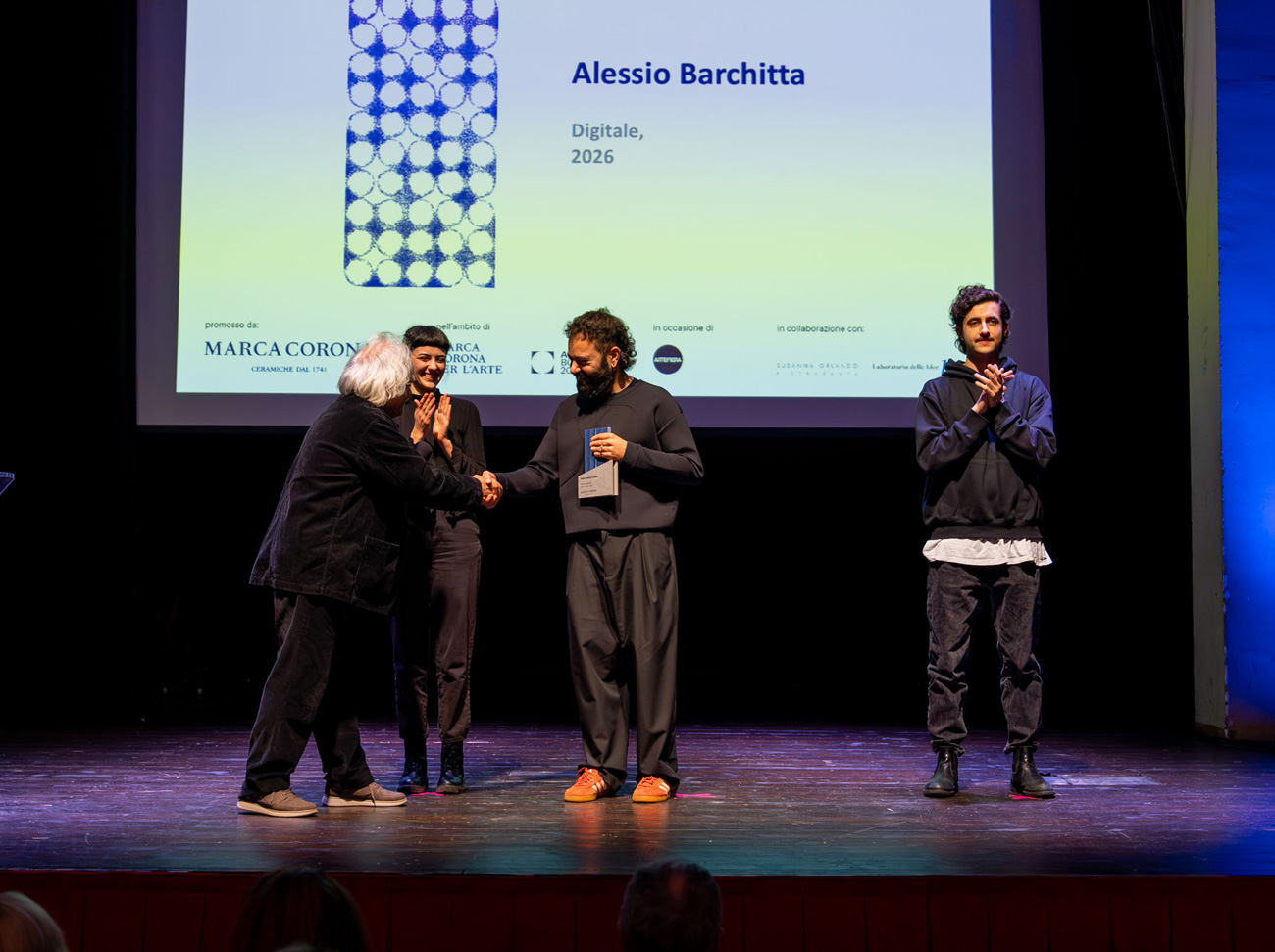 Cerimonia di premiazione con consegna del riconoscimento sul palco.