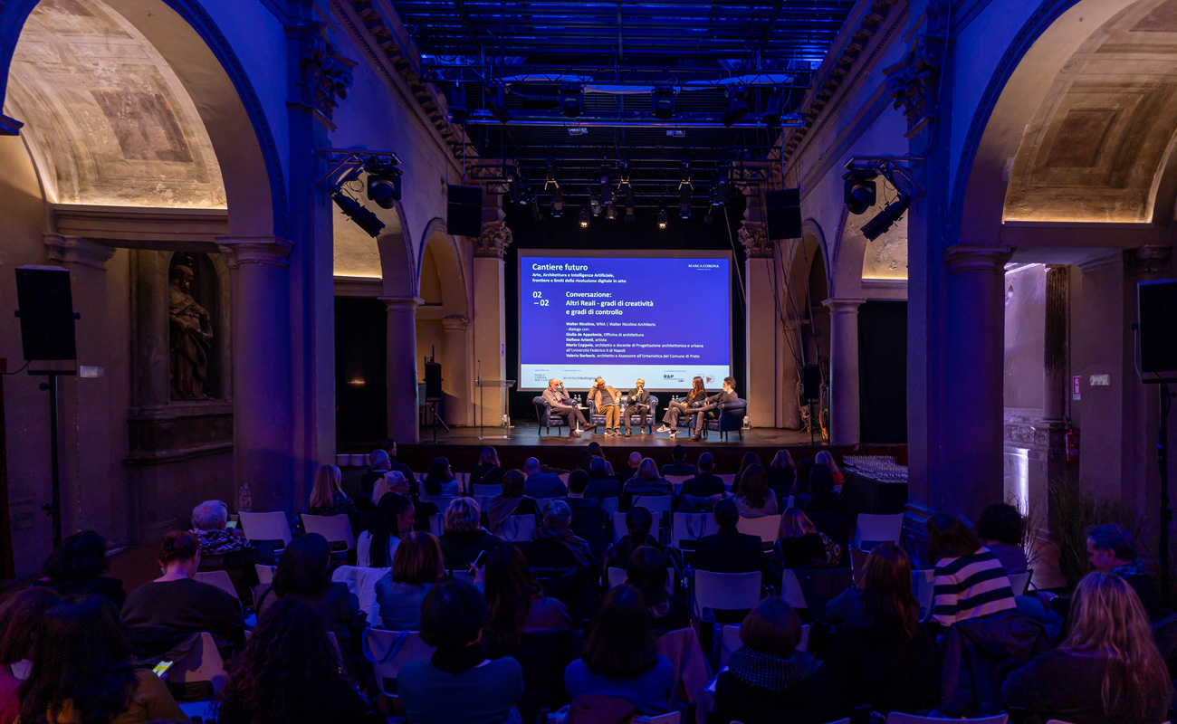 Teatro San Leonardo, Bologna: pubblico e relatori sul palco durante un convegno.