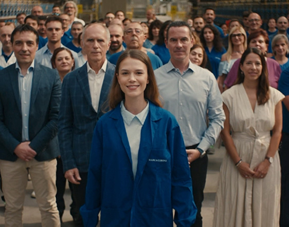 Group portrait of the Marca Corona team, an Italian porcelain tile manufacturer, with a young employee in the foreground, symbolising a united, innovative and inclusive company.