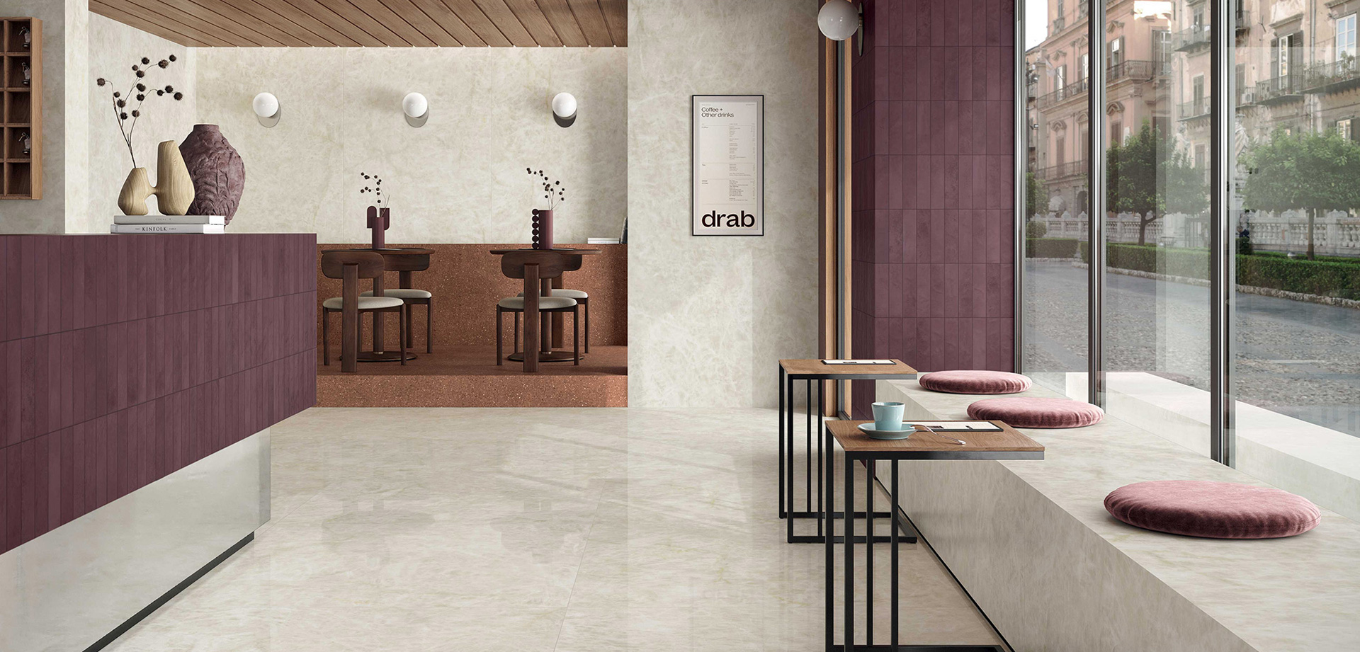 Innenraum eines Bistros mit Verkleidungen Scultorea Delicata: Wände in hellem Marmoroptik und weinfarbenen Einsätzen, mit Blick auf historische Gebäude.