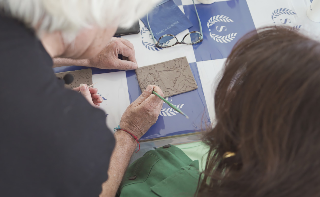 Artista al lavoro su bassorilievi in ceramica durante il laboratorio creativo.