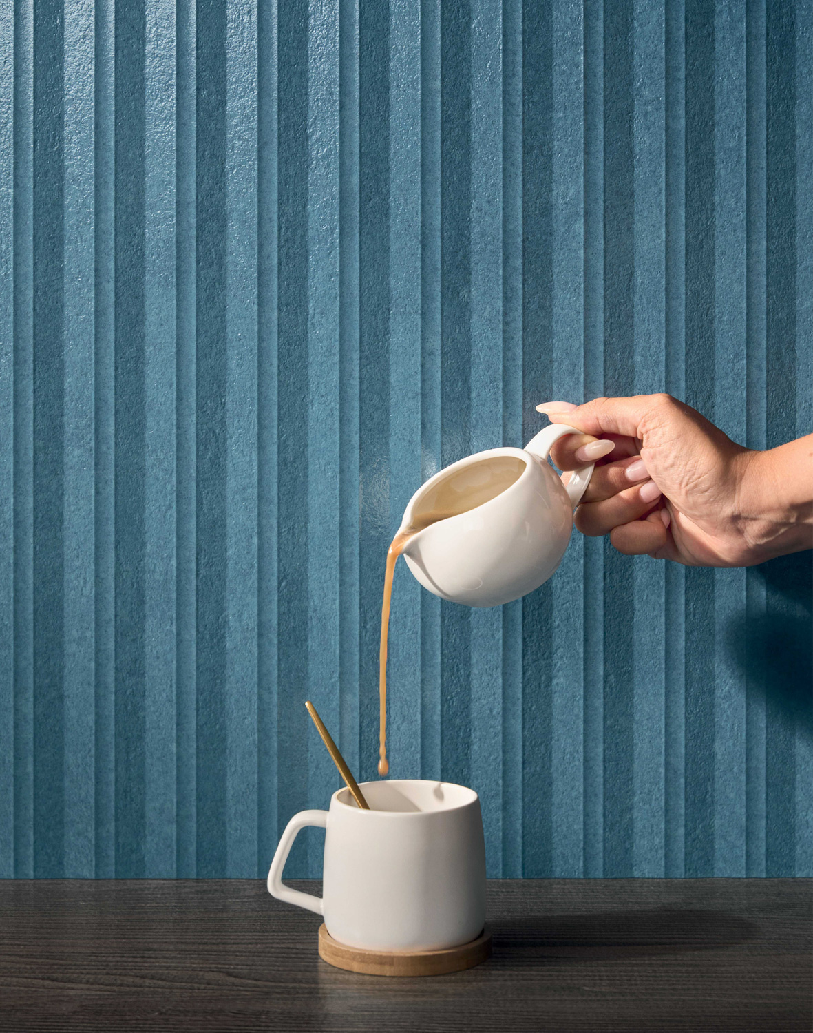 Modern bedroom with neutral headboard, blue ribbed wall, and terracotta vaulted ceiling by Marca Corona Arte Seta.