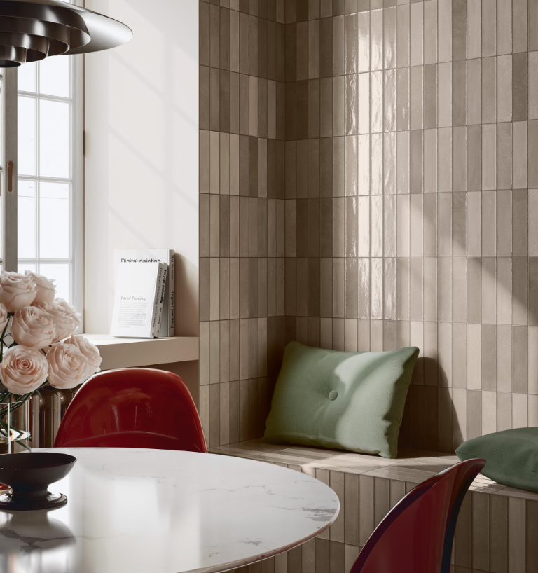 Angolo pranzo con rivestimento in listelli ceramici nei toni del beige e della tortora.