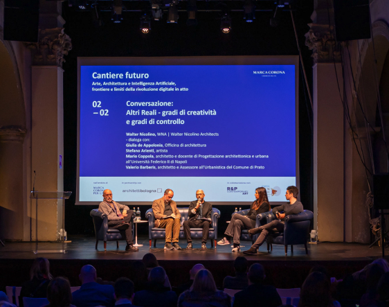 Conference on art and sustainability: speakers seated on stage discuss creativity and innovation in front of the audience.