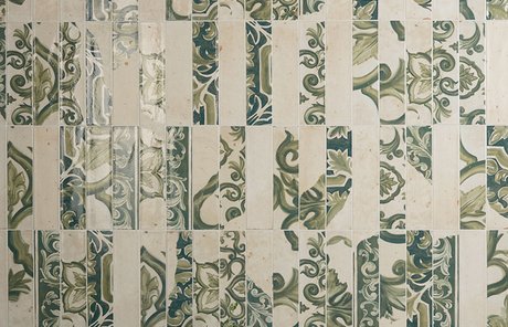 Rivestimento parete con piastrelle in gres effetto maiolica verde e  beige, pianta verde in vaso metallico e dettagli naturali in primo piano.