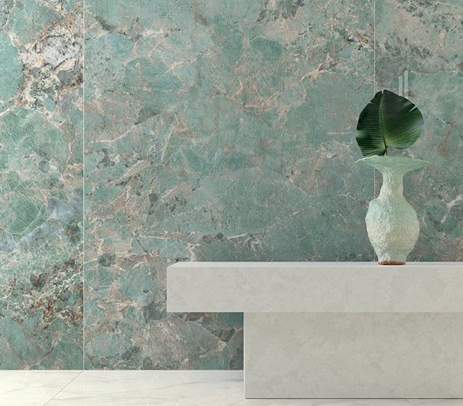 Wandverkleidung mit Platten in grüner Marmoroptik, strukturierter Oberfläche und kupferfarbenen Adern, mit Konsole und Deko-Vase.