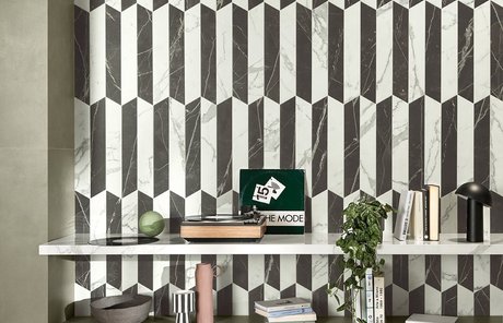Dekorative Wand mit Fliesen in weißer und schwarzer Marmoroptik mit geometrischen Mustern, Regalen und modernen Accessoires.