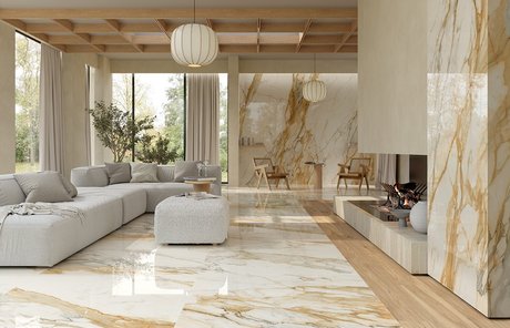 Raffiniertes Wohnzimmer mit glänzendem Boden in Calacatta-Gold-Optik, modernem Kamin und hellen Möbeln in schlichtem Design.