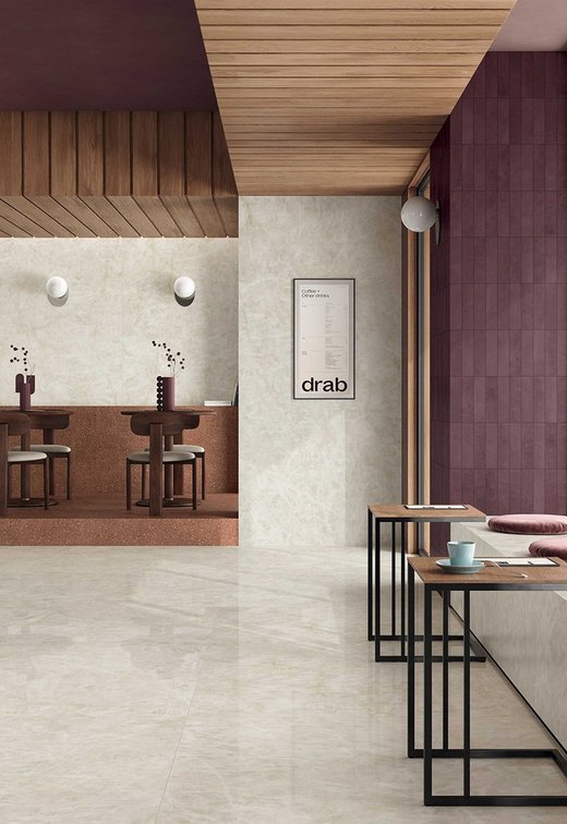 Contract-Umgebung mit Bodenbelag in hellem Marmoroptik, weinroten und holzfarbenen Wänden, minimalistischen Möbeln und gedämpfter Beleuchtung.