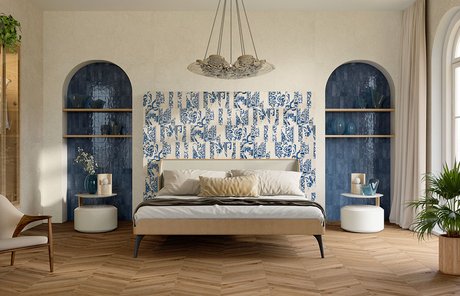 Camera da letto con pavimento in gres effetto legno chevron e rivestimento parete con maiolica blu e bianca, nicchie ceramiche blu e arredi moderni.