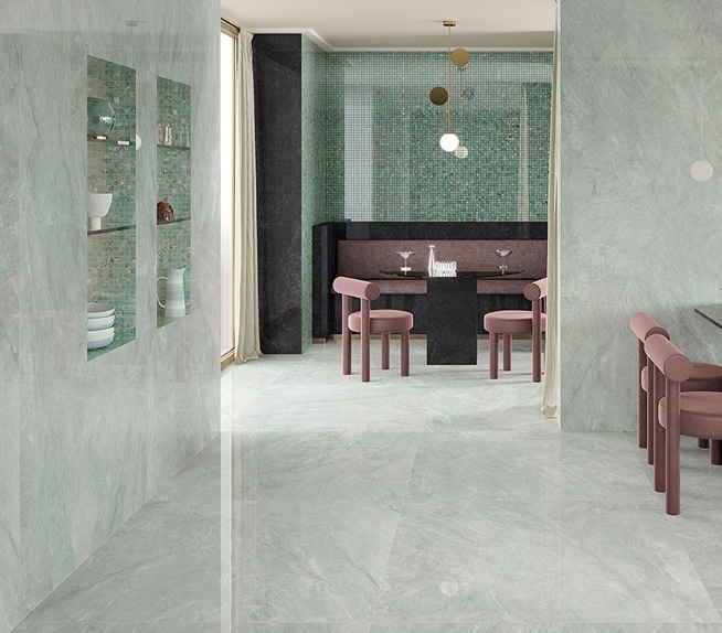 Objektbereich mit Bodenbelägen und Wandverkleidungen in hellgrüner Marmoroptik, passendem Mosaik und Möbeln in Bordeauxrot und Gold.