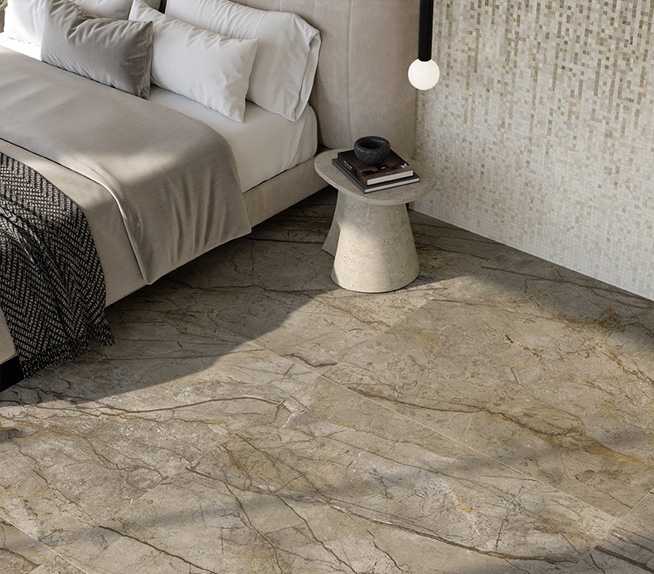 Schlafzimmer mit Bodenbelag aus Steinzeug in Braunmarmoroptik und heller Mosaikwand, Einrichtung in neutralen Farbtönen und natürlichem Licht.