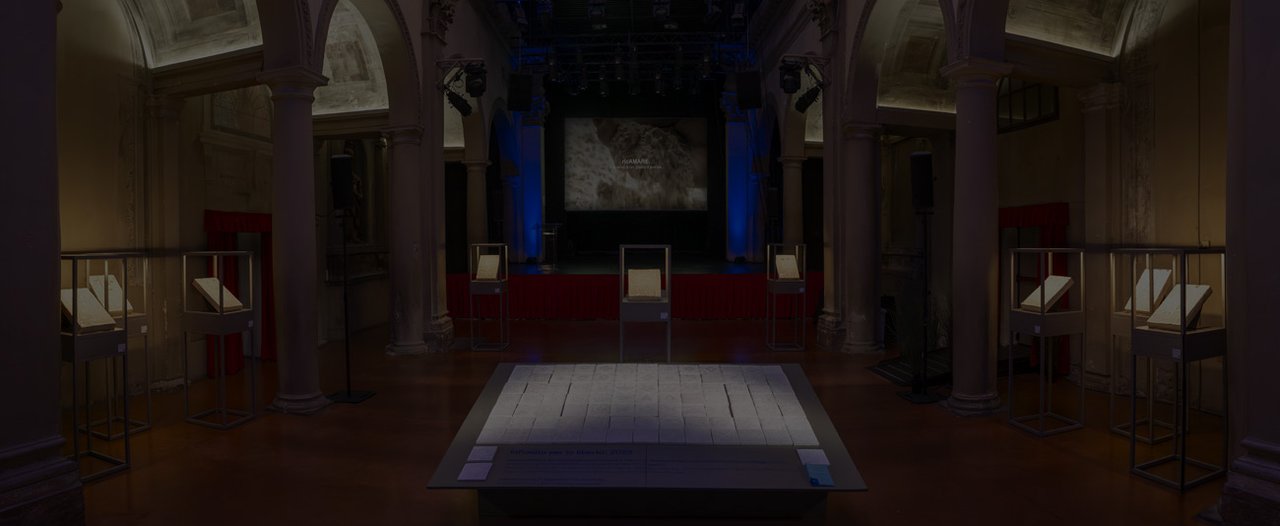 Vista panorámica de la exposición con instalaciones cerámicas y escenario iluminado.