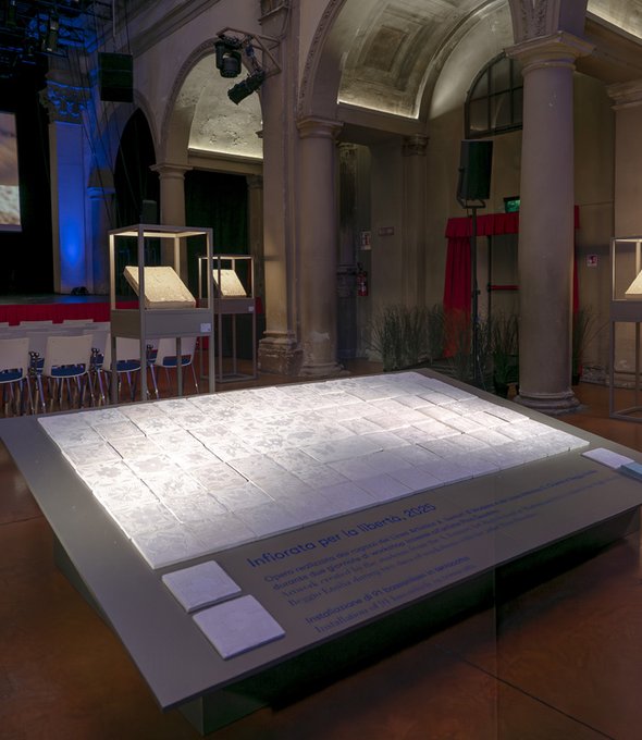 Instalación de baldosas cerámicas expuesta en una sala histórica con arcos y columnas.