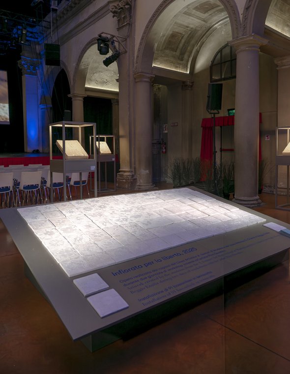 Instalación de baldosas cerámicas expuesta en una sala histórica con arcos y columnas.