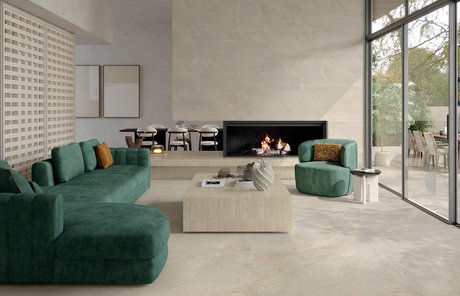 Modern living room with light stone‑effect porcelain floor and green sofa.