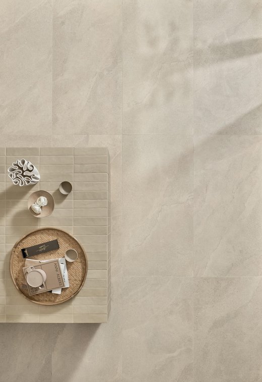 Top view of stone‑effect porcelain floor with coffee table and decorative objects.