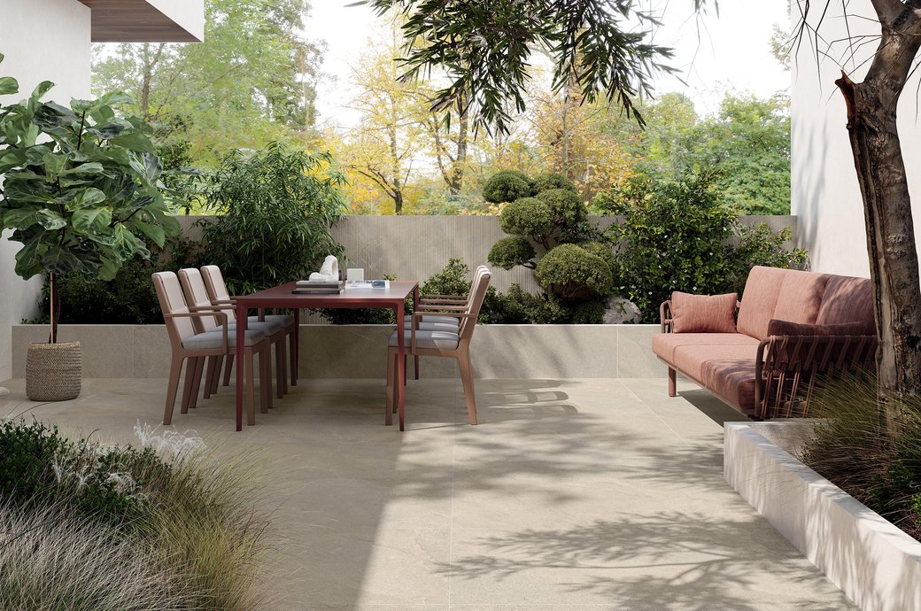 Outdoor terrace with stone‑effect porcelain flooring and dining table.
