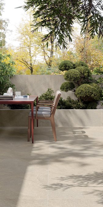 Outdoor terrace with stone‑effect porcelain flooring and dining table.