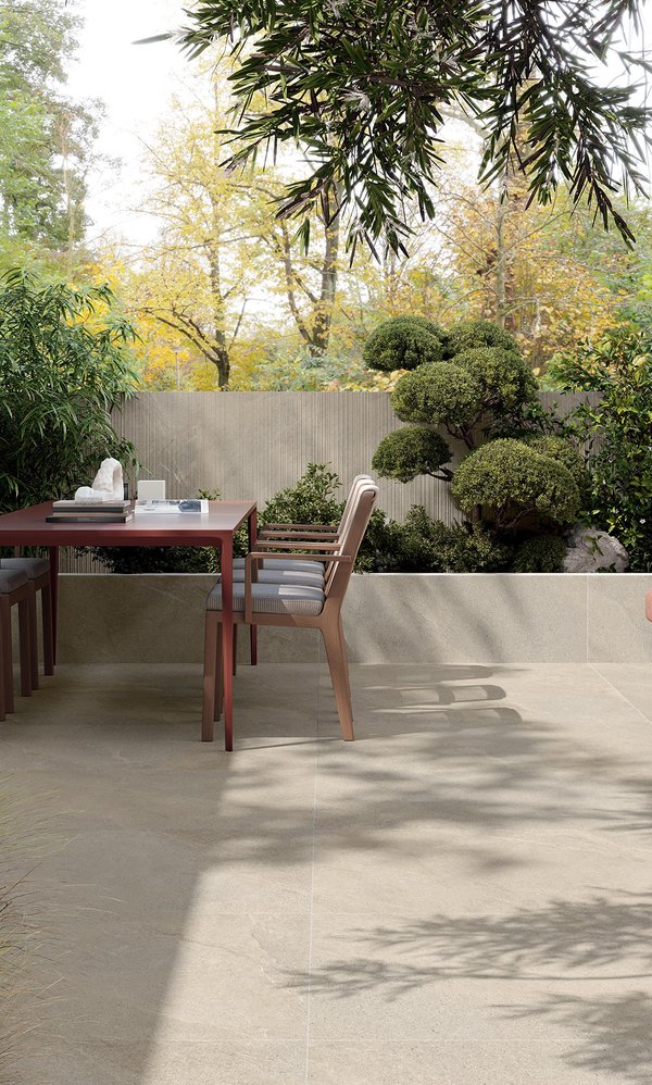 Terrasse extérieure avec sol effet pierre et table à manger.