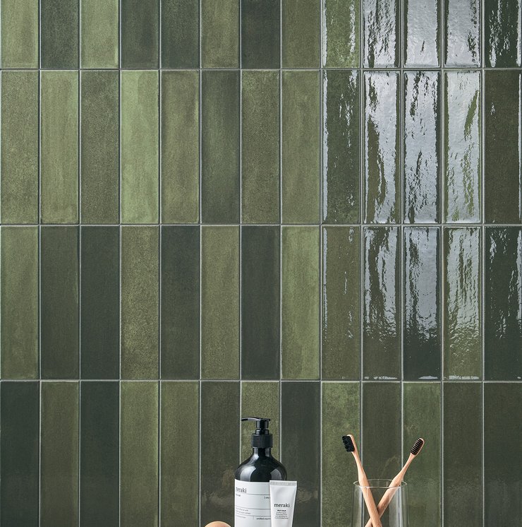 Modern bathroom with glossy green tile wall covering.