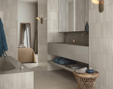 Минималистичная ванная со светлой прямоугольной плиткой и раковиной.