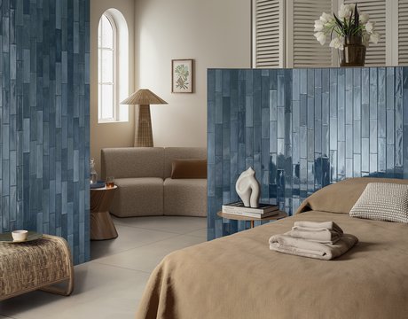 Bedroom with walls covered in glossy blue tiles.