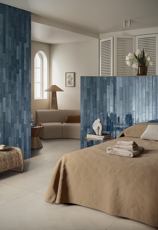 Schlafzimmer mit Wänden aus glänzenden blauen Fliesen.