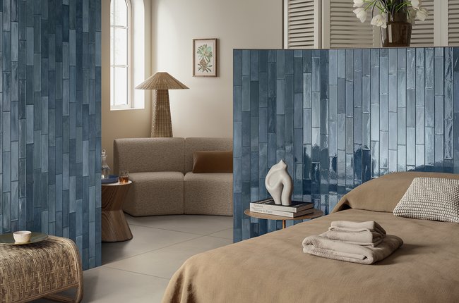 Bedroom with walls covered in glossy blue tiles.