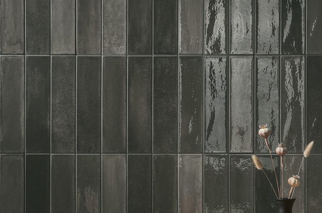 Wall with dark glazed tiles in an elegant restaurant setting.