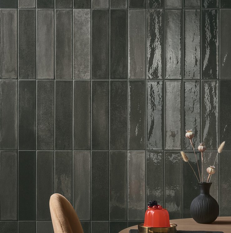 Wall with dark glazed tiles in an elegant restaurant setting.